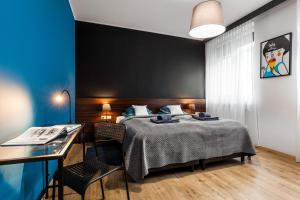 a bedroom with a bed and a desk at Apartamenty Black&White in Gdynia