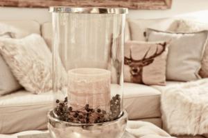 een glazen vaas met een kaars op een tafel bij HOME Suites Apartment 3 in Braunlage