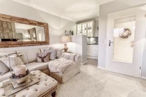 een woonkamer met een bank en een spiegel bij HOME Suites Apartment 3 in Braunlage