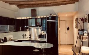 a kitchen with a black refrigerator and a table at Gorgeous Paris St Germain des Près in Paris