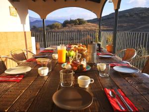 una mesa de madera con platos de comida. en Finca Pil - Casa rural con piscina, en Ríogordo