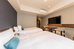 a hotel room with two beds and a flat screen tv at Tokyu Stay Sapporo Odori in Sapporo