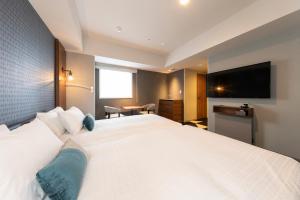 a hotel room with a large bed and a flat screen tv at Tokyu Stay Sapporo Odori in Sapporo