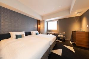 a hotel room with a large bed and a table at Tokyu Stay Sapporo Odori in Sapporo