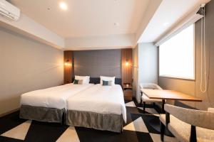 a hotel room with a bed and a desk and a window at Tokyu Stay Sapporo Odori in Sapporo