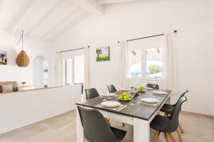 a dining room with a table and chairs at Villa BiniRe by 3VILLAS in Binibeca