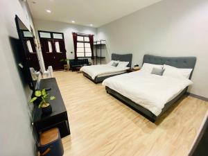 1 dormitorio con 2 camas y escritorio en 燕旅宿 en Neipu