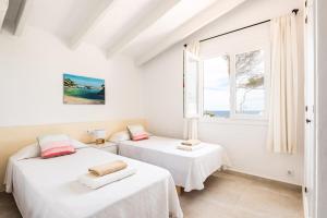 two beds in a room with a window at Villa BiniRe in Binibeca +14 photos