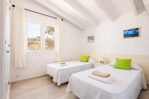 two beds in a white room with a window at Villa BiniRe by 3VILLAS in Binibeca +19 photos