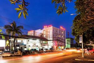 una calle de la ciudad por la noche con coches y edificios en ibis Vientiane Nam Phu, en Vientiane
