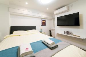 1 dormitorio con 1 cama grande y TV de pantalla plana en High Five Guest House, en Tokio