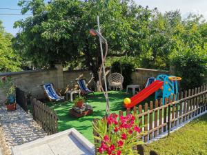 a backyard with a playground with chairs and a slide at Villa Holly in Balchik