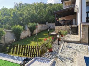 a garden with potted plants and a fence at Villa Holly in Balchik