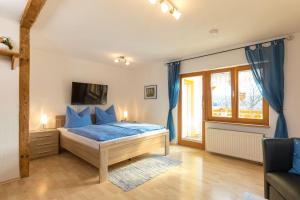 a bedroom with a bed with blue pillows at Apartment-mit-Balkon in Hergensweiler