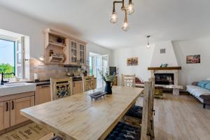 eine Küche mit einem Holztisch und ein Wohnzimmer in der Unterkunft Holiday Home Rustic in Kraljići