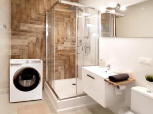 a bathroom with a shower and a washing machine at Apartament Litevski Deluxe in Lublin