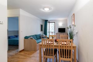 a dining room and living room with a table and chairs at Les Jardins de Ramel - Apt proche des pistes avec Wifi in Luchon +5 photos