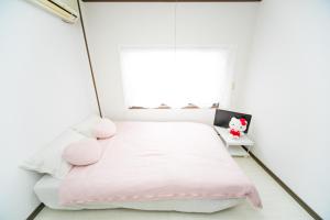 Una cama o camas en una habitación de Miraie Yokkaichi Kitahamacho