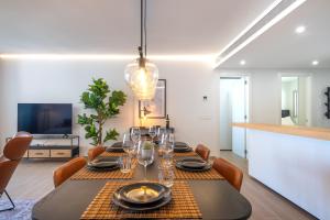 a dining room with a table and chairs and a television at Holiday Apartment The Wave Carvajal in Fuengirola