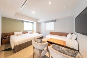 a hotel room with two beds and a flat screen tv at Tokyu Stay Sapporo Odori in Sapporo