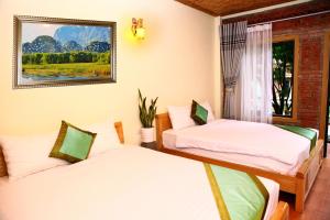 two beds in a room with a window at Tam Coc Valley Homestay in Ninh Binh +148 photos