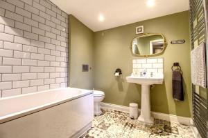 a bathroom with a tub and a toilet and a sink at Central Huddersfield House, inc parking in Huddersfield