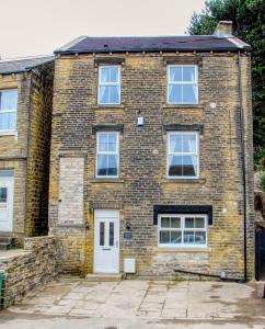 a brick house with a white door and windows at Central Huddersfield House, inc parking in Huddersfield