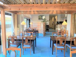 een eetkamer met houten tafels en stoelen bij Bayside Hotel Ryugu / Vacation STAY 63714 in Anan