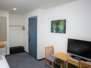 a room with a table and a tv and a table and a chair at Bayside Hotel Ryugu / Vacation STAY 63714 in Anan