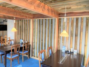 ein Esszimmer mit Holzwänden, Tischen und Stühlen in der Unterkunft Bayside Hotel Ryugu / Vacation STAY 63718 in Anan