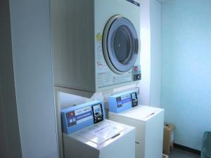 zwei Maschinen in einem Zimmer mit einer Waschmaschine in der Unterkunft Bayside Hotel Ryugu / Vacation STAY 63718 in Anan