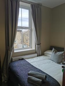 a small bedroom with a bed and a window at Central Huddersfield House, inc parking in Huddersfield