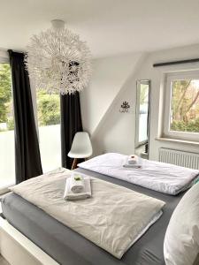 a bedroom with two beds and a chandelier at BUDE 17 in Timmendorfer Strand