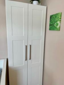 a white cabinet with two doors next to a wall at Ferienzimmer/wohnung am Kurstrand, WLAN in Zingst