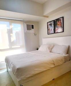 a bedroom with a large bed with a window at Steff's CONDO 1016 at CENTRIO Tower in Cagayan de Oro +4 photos