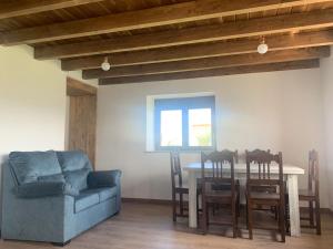 a dining room with a table and a blue couch at Casa Lin Nieva in Nieva