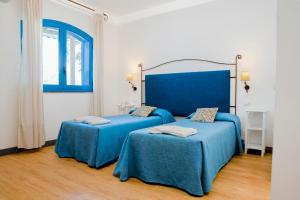 two beds in a room with blue sheets at Le Dune Sicily Hotel in Catania