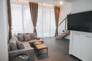 a living room with a couch and a flat screen tv at Cabo Villas in Arapya