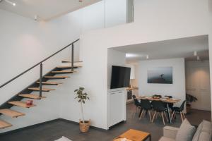 a living room with a staircase and a dining room at Cabo Villas in Arapya