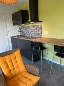 eine Küche mit einem orangenen Stuhl und einer Theke in der Unterkunft Sol Borsay - Studio de vacances à la campagne - Idéal pour 2 in Comblain-au-Pont
