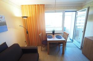 ein Wohnzimmer mit einem Tisch und einem Sofa in der Unterkunft Appartement 59 in Westerland