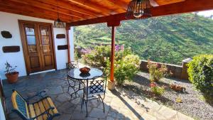 a patio with a table and chairs and a view at Casa Micaela in Garafía