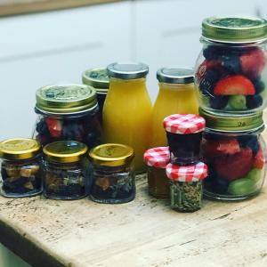 um grupo de frascos de fruta sobre uma mesa de madeira em Cornerways em Ventnor