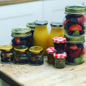 a group of jars of fruit on a wooden table at Cornerways in Ventnor