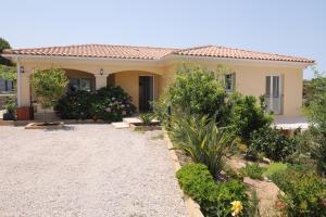 een klein geel huis met een grindoprit bij Villa Marine en bord de mer... in Lumio