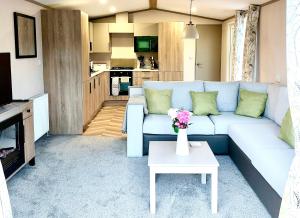 a living room with a couch and a table at Lake View at Pendle View Holiday Park BB7 4DH in Clitheroe
