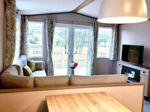 a living room with a couch and a television at Lake View at Pendle View Holiday Park BB7 4DH in Clitheroe