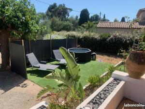 un jardín con 2 sillas y una hoguera en Maison provençale les fourmis en Les Issambres