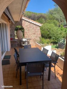 una mesa negra y sillas en un patio en Maison provençale les fourmis en Les Issambres
