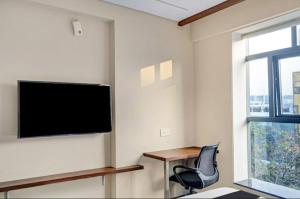a room with a chair and a television on a wall at HOTEL V in Hyderabad